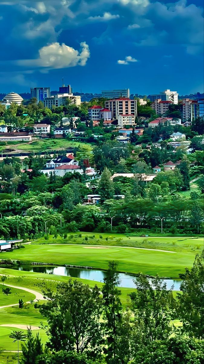 Lush green landscape of the Kigali Golf Resort and Villas with the city skyline and the Kigali Convention Centre in the background, luxury travel in Rwanda.