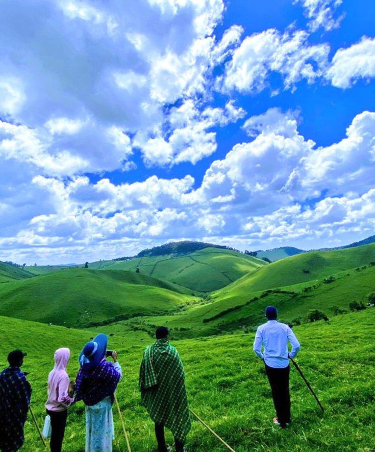 Tourists enjoying scenic views of rolling green hills at Ibere rya Bigogwe in Rwanda with Road Rave Tours